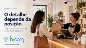 Atendente entrega uma compra no balcão, com terminal de pagamento e câmera de segurança instalada no teto.