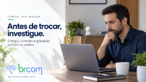 Profissional examina um notebook em escritório, com uma câmera de segurança sobre o aparador ao fundo.