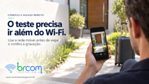 Homem consulta no celular uma imagem da entrada residencial, com mala ao fundo antes de uma viagem.