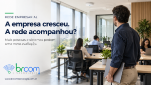 Gestor observa estações de trabalho ocupadas em escritório moderno com ponto de acesso instalado no teto.