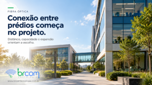 Edifícios de um complexo empresarial moderno conectados por passarela, com escritórios e áreas externas ajardinadas.